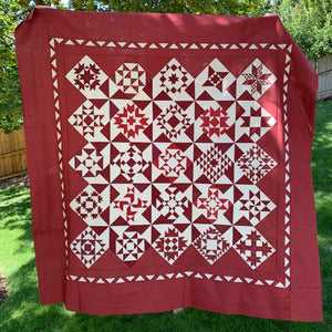 The Magic of Christmas  in red and white by Primitive Gatherings quilt top hanging in the front yard
