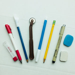 Variety of marking tools including pens, pencils, chalk, and markers.