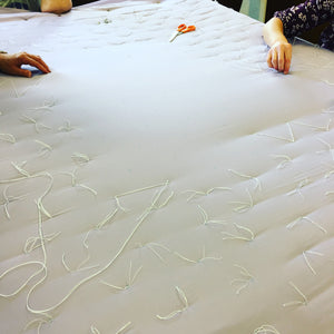 Quilting Bee - hand tying a quilt