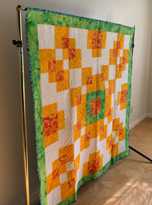 Hanging a quilt - Orange and Green Quilt hanging on a bar rack