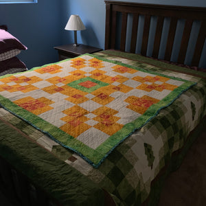 Quilts layered on a spare bed for storage