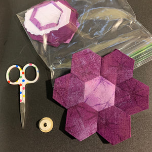 English Paper Piecing a purple hexagon flower.