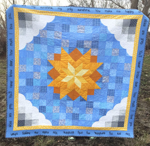 You are My Sunshine Quilt Pattern with grey clouds, blue sky, and a yellow sun