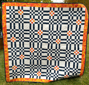 Color Seeds Quilt in Blue, Orange, and white. Like a plaid with lots of squares
