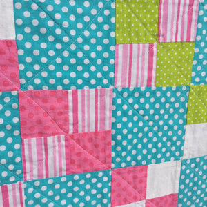 Close up of Alana Quilt Pattern - Easy quilt made in squares with pink, teal, white, and green