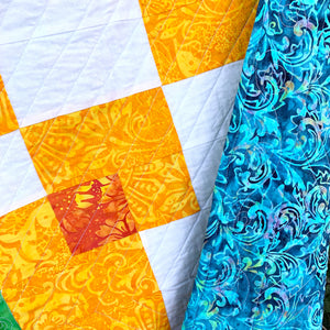 Counterbalance Quilt  made in Orange, Yellow, Green, and White. Beginner quilt, made with squares.